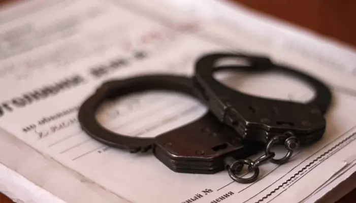 наручники лежат на папке с надписью "Уголовное дело"