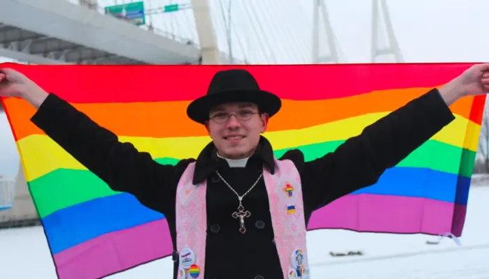 квир-священник Александр Хмелёв с прайд-флагом в руках
