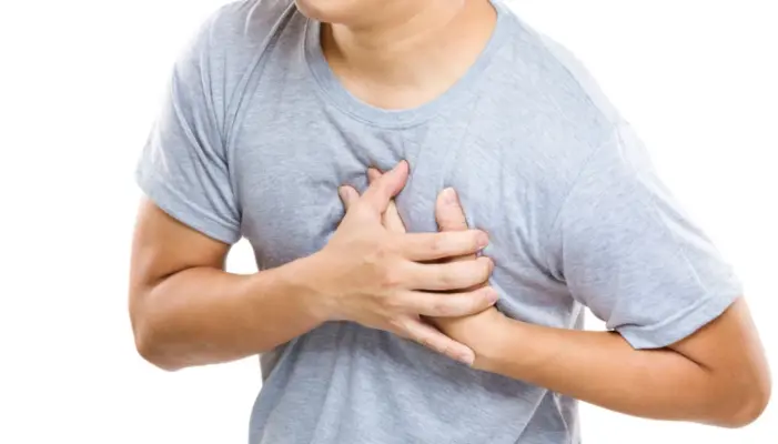 на иллюстрации молодой человек держится за грудь в области сердца, эти типичная иллюстрация инфаркта миокарда