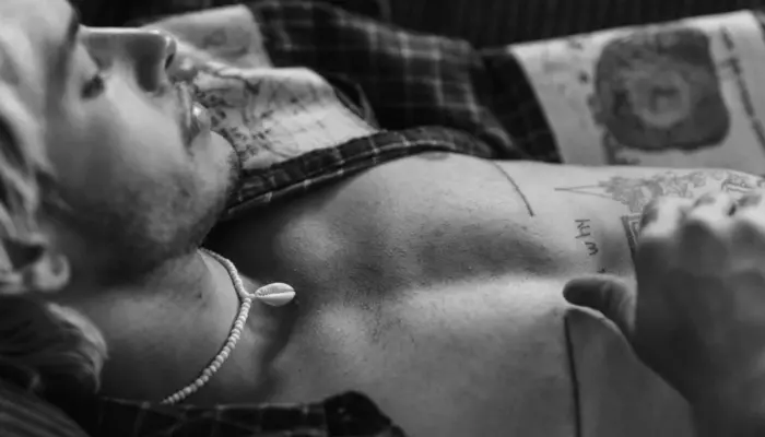 чёрно-белое фото трансгендерного мужчины с заметными шрамами от верхней операции