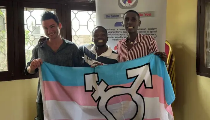 Транс-активист Ян Дворкин с коллегами из Танзании и транс-флагом