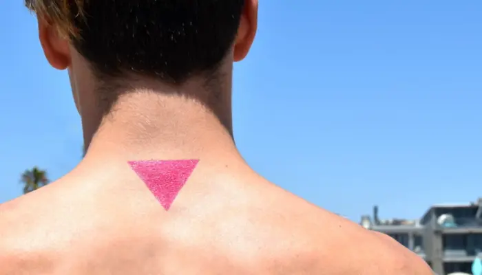 спина, шея и затылок мужчины с татуировкой в виде розового треугольника