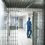 решётчатая дверь СИЗО и виден сотрудник Росгвардии