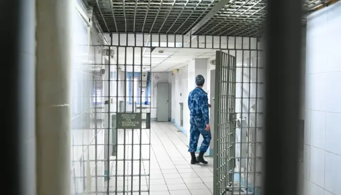 решётчатая дверь СИЗО и виден сотрудник Росгвардии