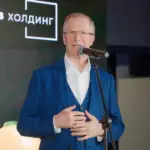 Виктор Шкулёв выступает на фоне логотипа своей формы &laquo;Шкулёв Холдинг&raquo;