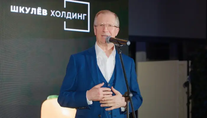Виктор Шкулёв выступает на фоне логотипа своей формы &laquo;Шкулёв Холдинг&raquo;