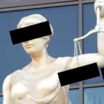 Статуя Фемиды, на фото чёрными прямоугольниками закрыты глаза и чаши весов в её руке