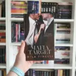 Книга Милы Финелли «Цель мафии» на английском на фоне книжной полки