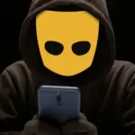 человек с логотипом Grindr вместо лица смотрит в телефон в темноте