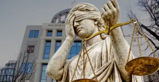 Статуя Фемиды делает фейспалм на фоне здания Московского городского суда