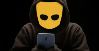 человек с логотипом Grindr вместо лица смотрит в телефон в темноте